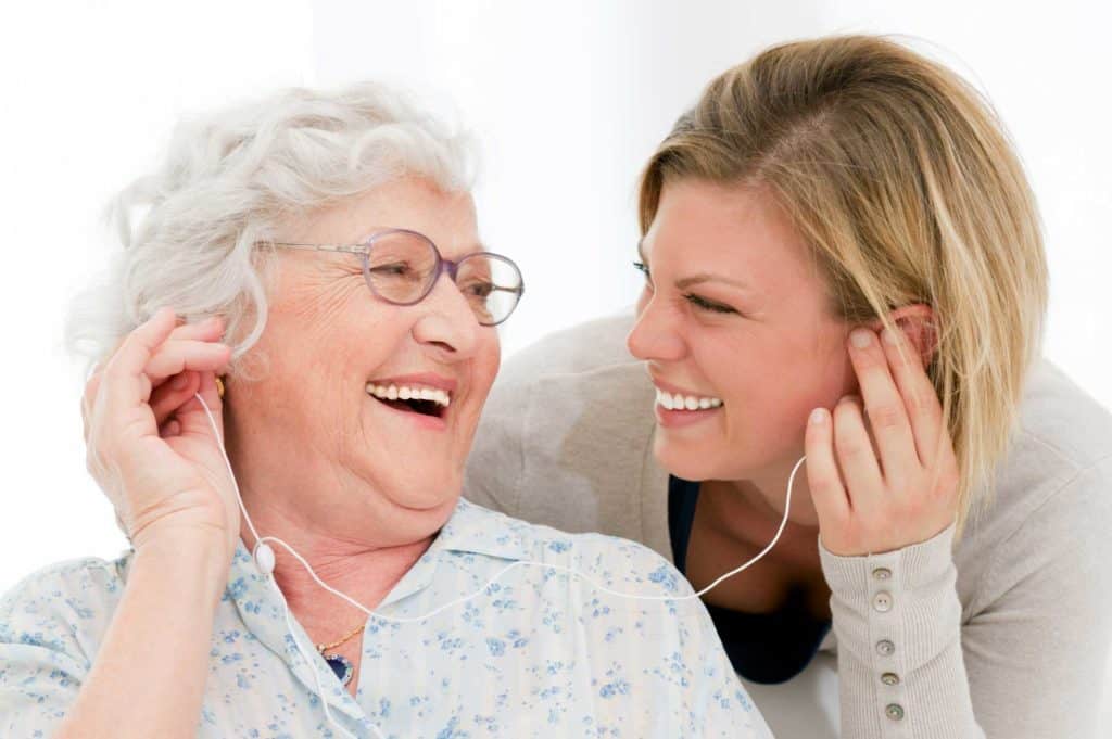Old Woman and Young Caregiver Enjoying Music Together